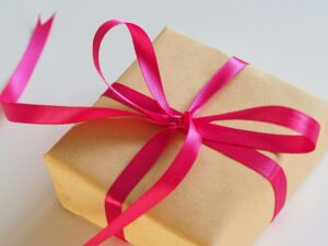 Wrapped birthday gift in brown kraft paper tied with a bright pink ribbon.